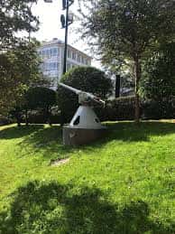 Vista de la Plaza de Carlos I con monumento y vegetación en primer plano