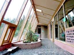 Interior del invernadero con plantas y paredes de vidrio inclinadas