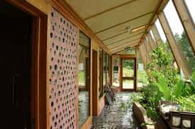 Pasillo interior con jardín vertical y muros de ladrillo perforado