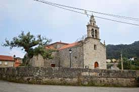 Iglesia de San Salvador de Coruxo desde la calle con campanario y muro de piedra