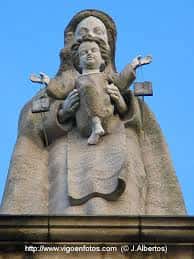 Estatua de la Virgen del Carmen con el Niño Jesús en la parte superior de la iglesia