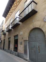 Vista exterior del Palacio de Argensola con fachada de ladrillo y balcones de hierro