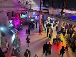 Ambiente festivo en La Terminal FICC con iluminación de colores y asistentes durante un evento