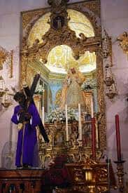 Altar principal del santuario con imagen de la Virgen de las Angustias y estatua del Cristo de la Salud en procesión