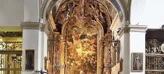 Interior de la iglesia mostrando un retablo barroco dorado con pintura religiosa central
