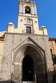 Detalle de la entrada principal de la iglesia con arco de piedra y torre superior