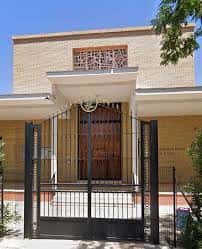 Entrada principal de la iglesia con portón metálico y fachada de ladrillo