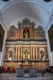 Interior de la iglesia mostrando el retablo mayor dorado, altar y bóveda decorada