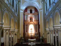 Interior de la nave central de la Iglesia de San Benito con altar mayor y columnas de estilo clásico