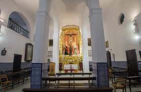 Interior de la capilla con altar dorado y columnas decoradas con azulejos
