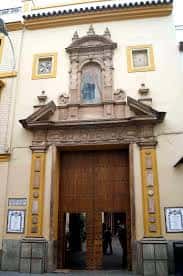 Vista frontal de la iglesia con puertas abiertas y detalles arquitectónicos barrocos
