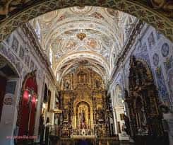 Interior de la iglesia con bóveda decorada y retablo dorado en el altar mayor