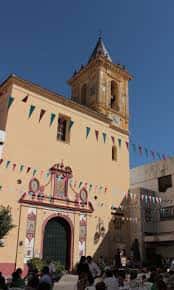 Vista exterior de la Basílica de María Auxiliadora con fachada amarilla y campanario bajo cielo azul