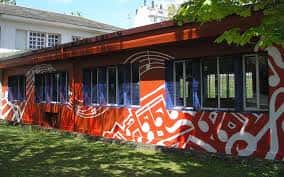 Fachada exterior de la Casa da Música en Lugo con murales artísticos y vegetación