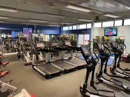Interior del gimnasio con equipamiento de cardio y máquinas de entrenamiento