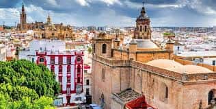 Vista panorámica de la Iglesia de la Anunciación desde una altura con el skyline de Sevilla al fondo