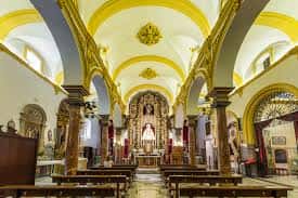 Interior de la iglesia mostrando la nave central con bóvedas decoradas y columnas de mármol