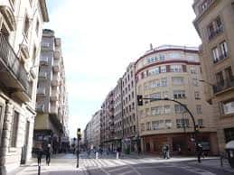 Calle Olaguibel con edificios residenciales y tráfico peatonal en un día soleado