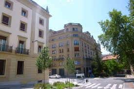 Esquina de la calle Olaguibel con edificios clásicos y árboles en primer plano