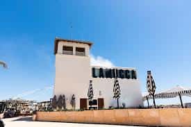 Fachada exterior del restaurante Lamucca del Mar con su distintivo letrero y cielo azul