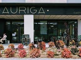 Fachada exterior de Auriga Gastrobar con terraza y vegetación decorativa