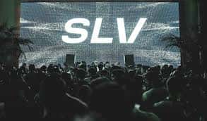 Interior del club con pantalla gigante mostrando el logo SLV y multitud de asistentes