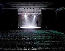 Interior del escenario de La Cochera Cabaret con cortinas y luces de escenario