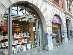 Fachada de la librería Elkar en Bilbao con escaparate iluminado y entrada principal