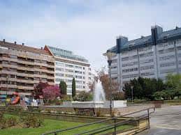 Plaza de San Cristóbal con fuente central, jardines y edificios residenciales al fondo bajo cielo despejado