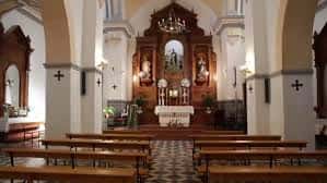Interior de la iglesia con altar principal, retablo dorado y bancos de madera en nave central