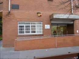 Vista lateral del edificio con rampa de acceso y ventana con reja