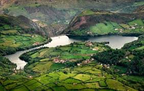 Perspectiva aérea del embalse con campos de cultivo y pequeñas aldeas en las laderas