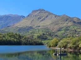 Embalse de Los Alfilorios con montañas al fondo y un muelle de madera en primer plano