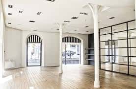 Interior del espacio Yimby Street con suelo de madera y columnas blancas decorativas