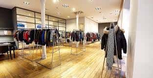 Vista del interior del local con exhibición de ropa y mobiliario moderno