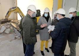 Grupo de personas en casco de seguridad revisando obras de renovación en el interior del centro cultural