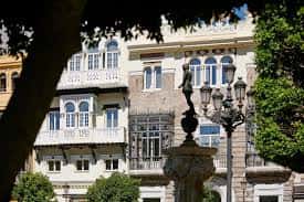 Fachada histórica del Mercer Plaza Sevilla con balcones y farolas tradicionales