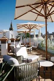 Zona de lounge en la terraza del hotel con sombrillas y mobiliario moderno