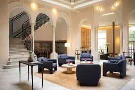 Lobby principal del Mercer Plaza Sevilla con escalera de caracol y sofás azules