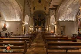 Nave central de la iglesia con bancos de madera y luz natural