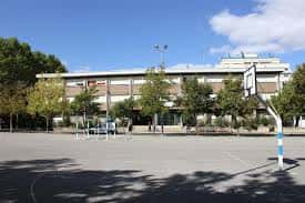 Vista exterior del edificio principal de Abendaño Ikastola con patio deportivo