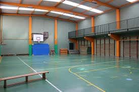 Pabellón deportivo interior con cancha de baloncesto y gradas
