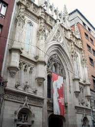 Fachada gótica del Museo de Reproducciones de Bilbao con detalles arquitectónicos y una bandera roja