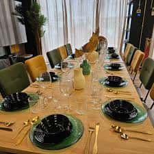 Mesa de banquete preparada para evento con vajilla elegante y decoración moderna