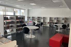 Interior moderno de la Biblioteca Zazpikale con estanterías blancas y zona de lectura con mesas redondas