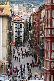 Vista panorámica de la calle Zazpikale en el Casco Viejo de Bilbao con edificios tradicionales y gente caminando