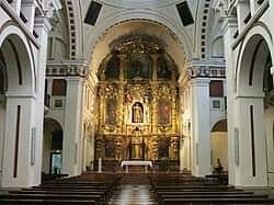 Interior de la iglesia con vista al altar mayor dorado y naves laterales