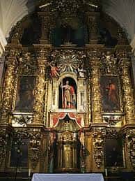 Detalle del retablo mayor dorado con esculturas religiosas y decoración barroca