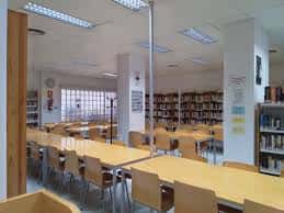 Sala de lectura de la biblioteca con mesas y estanterías