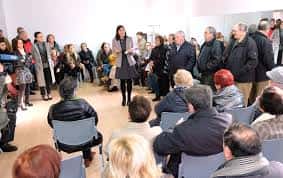Interior del centro cívico durante una reunión comunitaria con asistentes sentados
